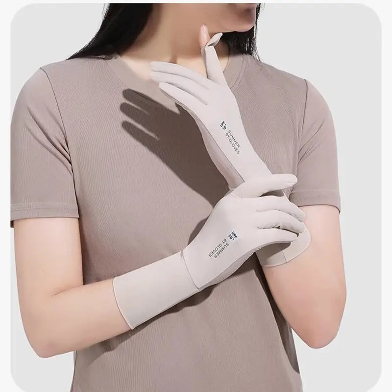 Une paire de gants de cyclisme pour femmes de couleur gris clair, assurant une protection contre les UV, fabriqués dans un tissu lisse avec des longues manches, affichés depuis le côté arrière.
