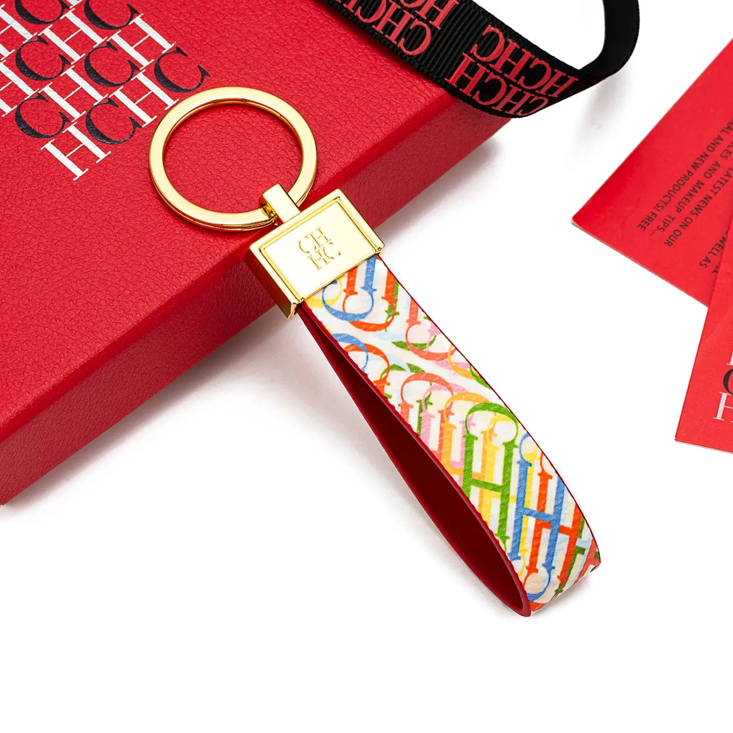 Leather logo keychain designer fashion accessory featuring a colorful multicolored h logo pattern with a gold-tone metal ring and rectangular clasp.