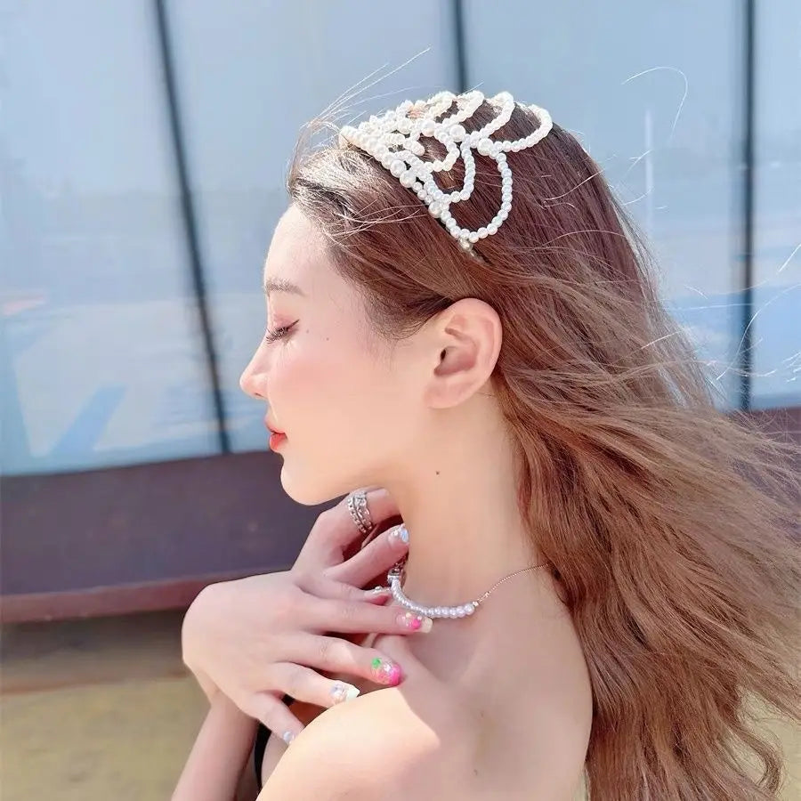 A delicate white pearl bridal crown hair band with an intricate floral design and elegant tassel headpiece.