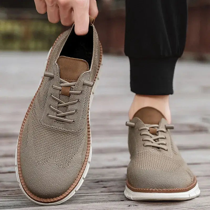 Chaussures derby brogue décontractées en maille, pour hommes, avec un matériau beige, des accents en cuir marron, un design à laçage et une semelle en caoutchouc blanc.