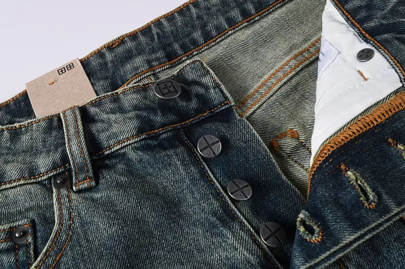 Men’s distressed blue acid wash denim shorts featuring dark-wash denim with brown stitching and black metal buttons.