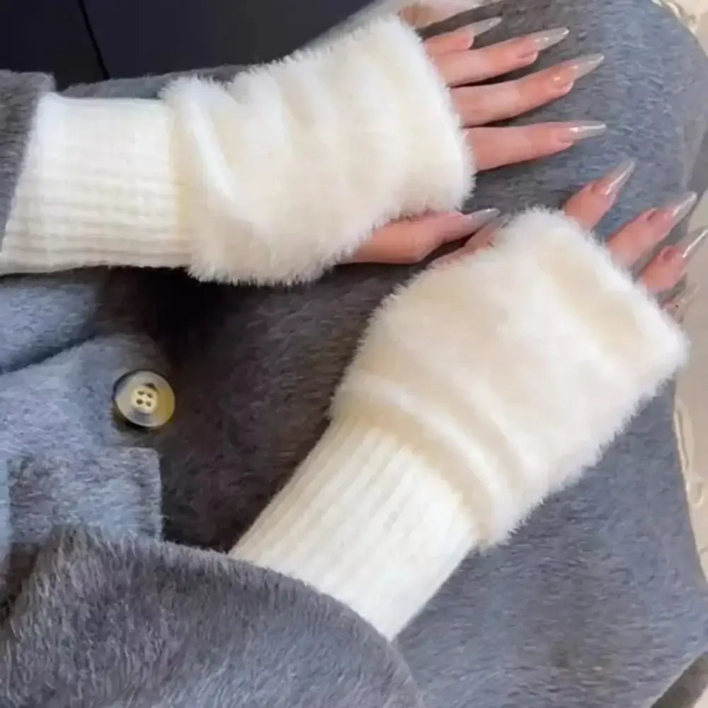Cremefarbene flauschige fingerlose Strickhandschuhe für Damen mit einem gerippten Strickbündchen, ausgelegt für Wärme und Komfort.