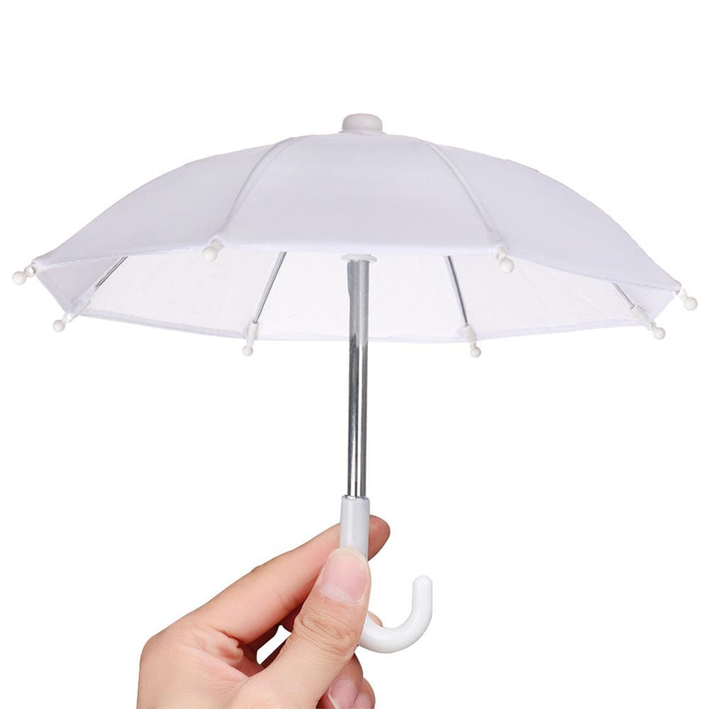 A miniature white doll umbrella with a silver shaft and a curved white handle held in hand for bjd accessories.