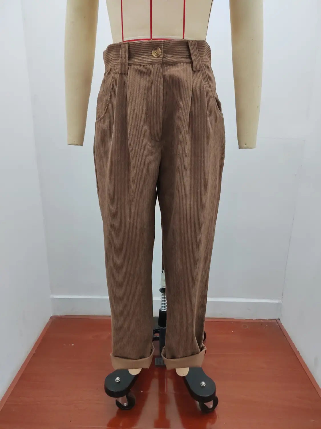 Pantalon en velours côtelé brun taille haute ample avec des plis, présenté sur un mannequin.