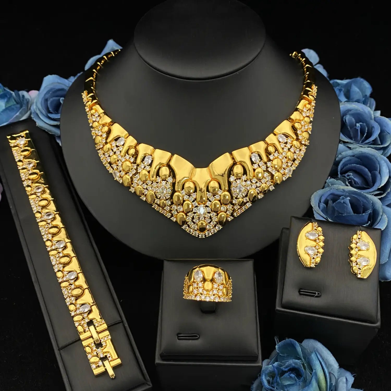 Ensemble de bijoux géométriques en zircon doré comportant un collier doré orné, avec des motifs géométriques et circulaires complexes, rehaussés de pierres claires scintillantes.