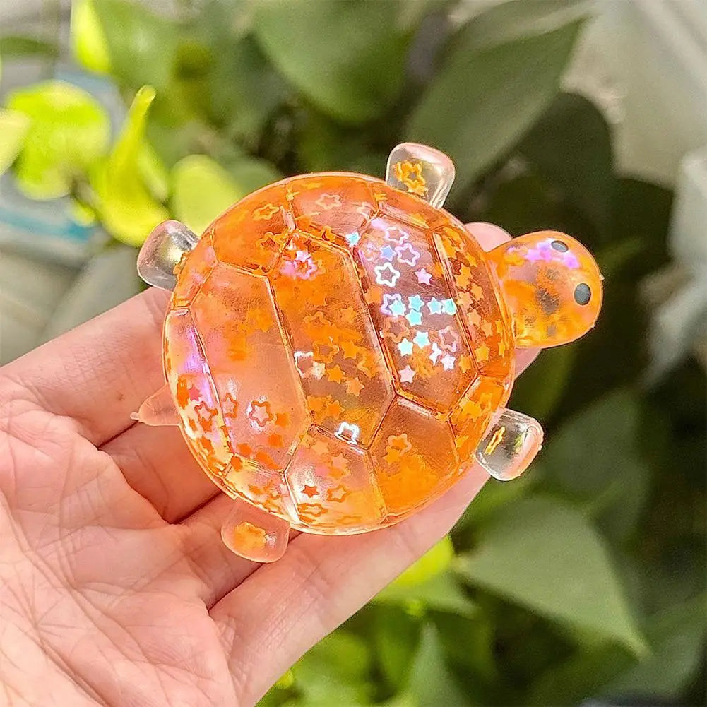 Ein durchscheinender orangefarbener Harz-Schildkröten-Spielzeug-Fidget-Spielzeug-Stressball mit eingearbeitetem sternförmigem Glitzer und klaren Plastikarmlimbs, entworfen zur soft Knautsch-/Quetsch-Stresslinderung