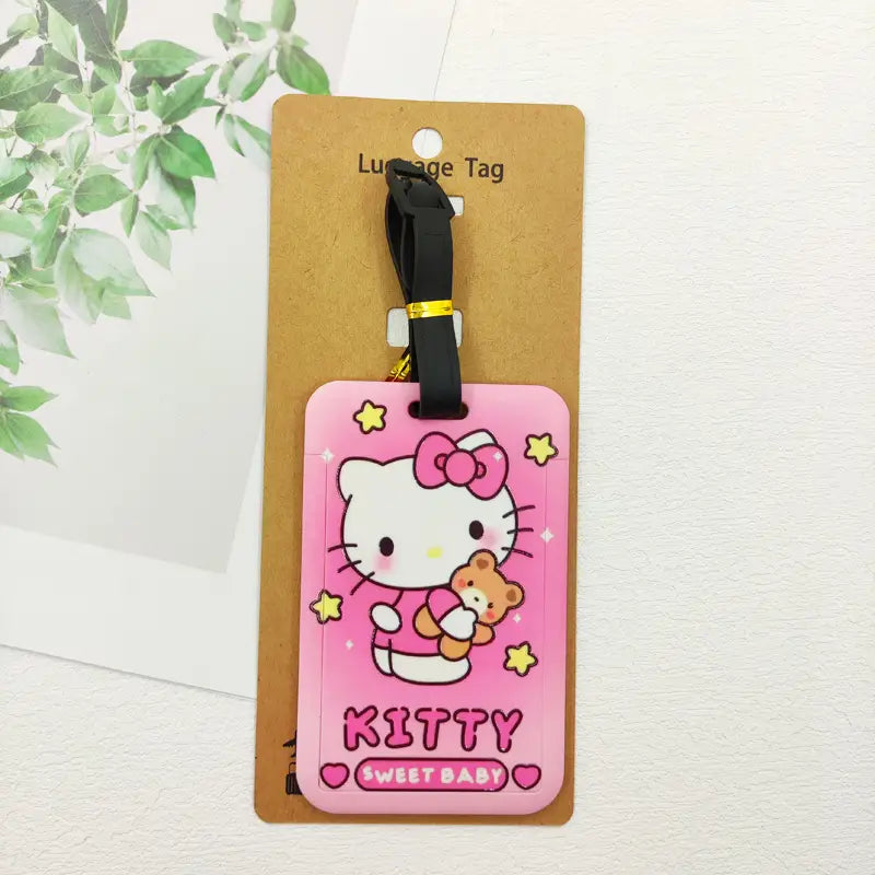 Étiquette de bagage Hello Kitty en silicone rose avec un design de nœud et d’ourson, fixée à une sangle noire pour l’étiquetage de l’identification de la valise.