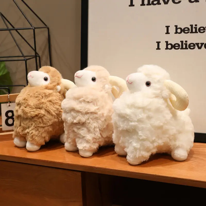 Drei Plüschschaf-Geschmacktiere mit flauschigem wolligem Körper in Beige, Off-White und Weiß, mit weichen schwarzen Knopfaugen und geschwungenen Hörnern in niedlichem Kawaii-Weichpuppen-Design