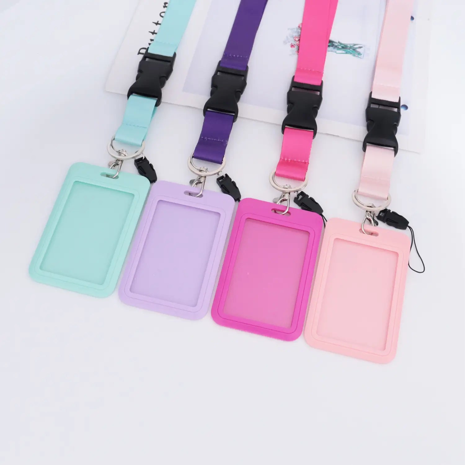 Pastellfarbene einfarbige Lanyard-Ausweishalter in Mint-Lavendel, Fuchsia und Rosa mit passenden Silikonhaltern sowie farblich passenden Metall-Anhängen aus Zinklegierung
