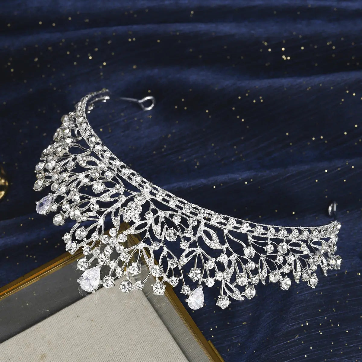 Une tiare de mariage en cristal de strass argent, au motif complexe de feuilles et de vignes, avec des cristaux en forme de goutte suspendus pour les mariages.