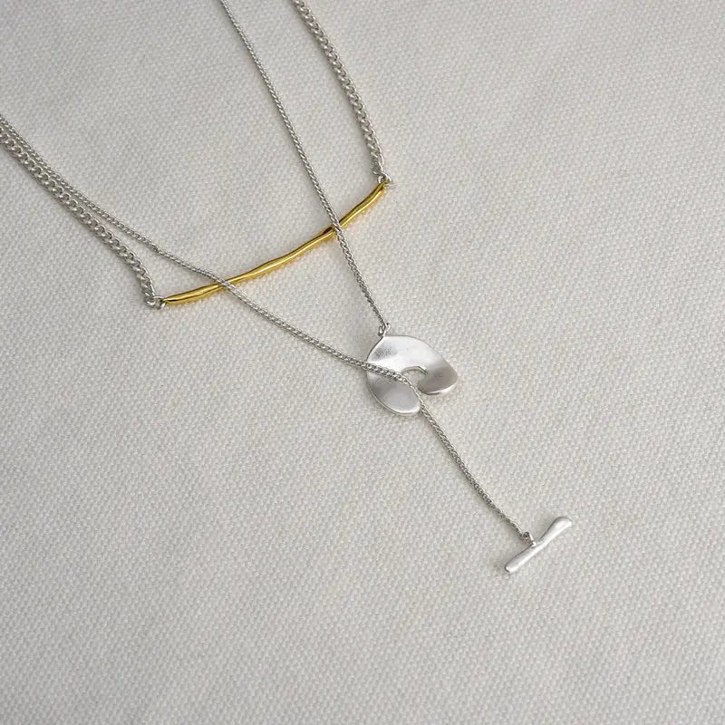 Collier pendentif à superposition géométrique doré pour femmes, présentant des pendentifs superposés minimalistes circulaires et en forme de barre, en argent et en or, avec une attache à t-bar.