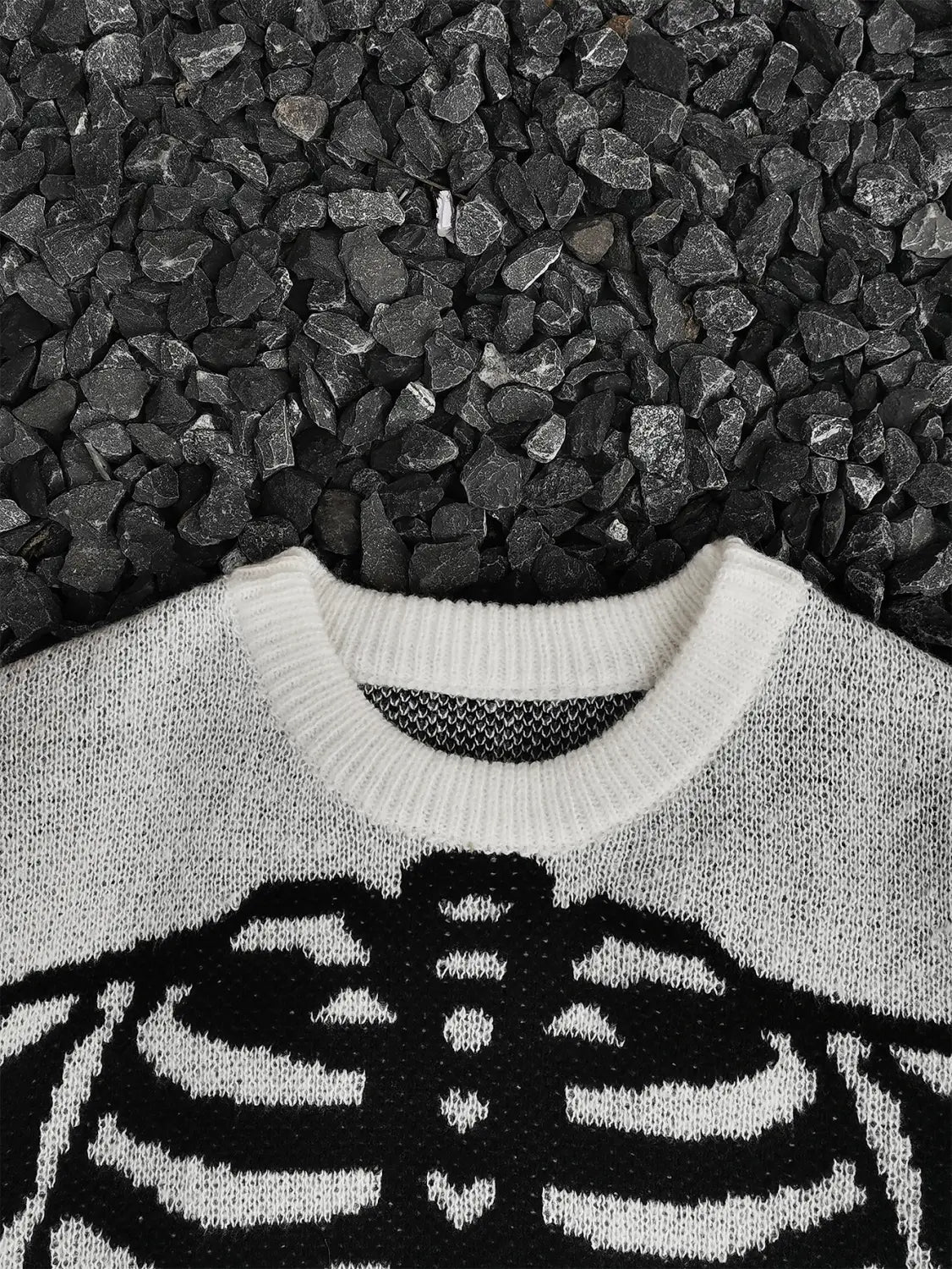 Pull gothique à jacquard squelette tricoté noir et blanc pour hommes, présentant un motif de cage thoracique bien visible sur l’avant.