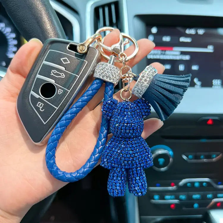 Rhinestone bear keychain with blue beaded teddy bear, braided leather strap, and crystal-encrusted tassel.