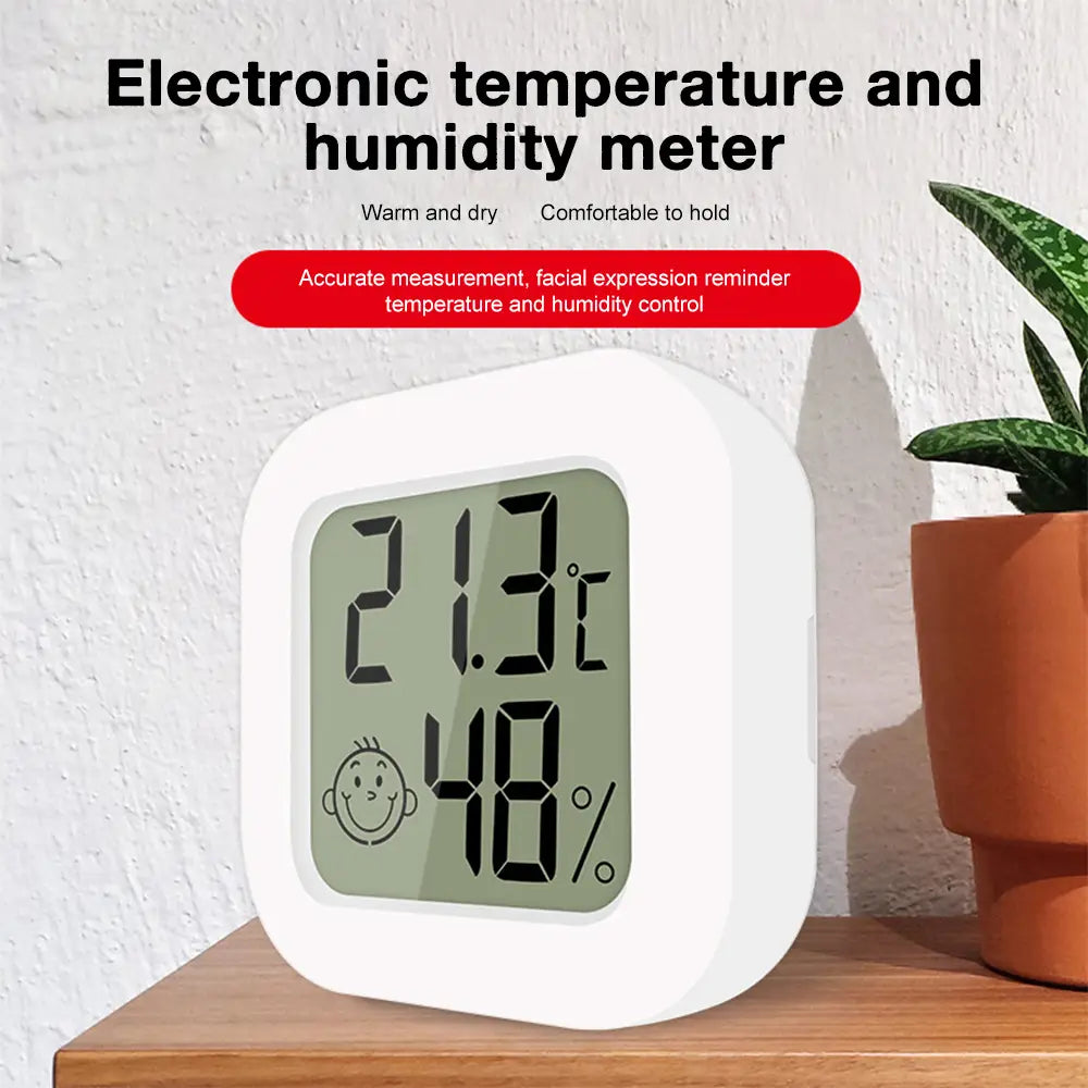 White square-shaped digital thermometer and hygrometer room sensor with a digital display showing 21.3°c temperature 48 percent humidity and a smiling face icon offering accurate measurement range.