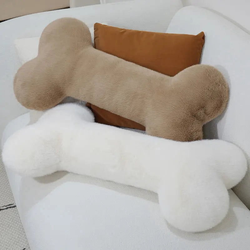 two kawaii bone shape plush pillows in beige and white with a soft fuzzy texture designed as a shape plush pillow for comfortable naps