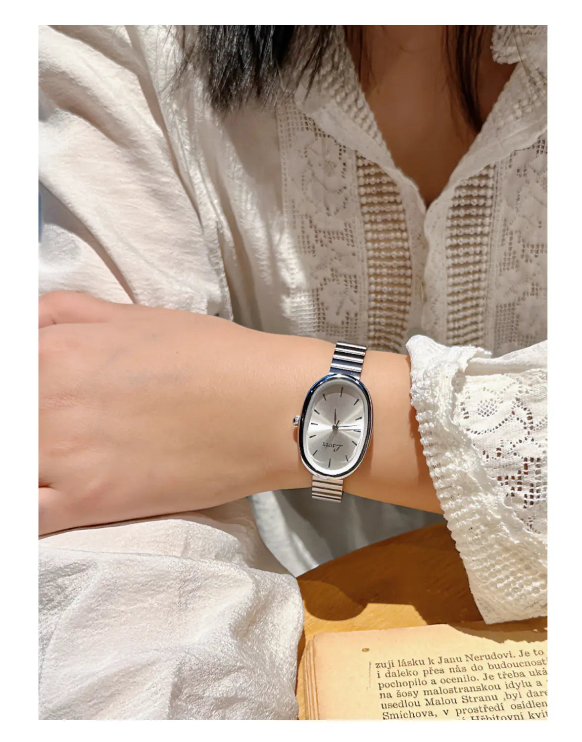 女性向けのシルバーの楕円形フェイスのクォーツウォッチ。上品なミニマリストデザインで手首に着用する、すっきりとしたメタリックバンドを特徴とします。