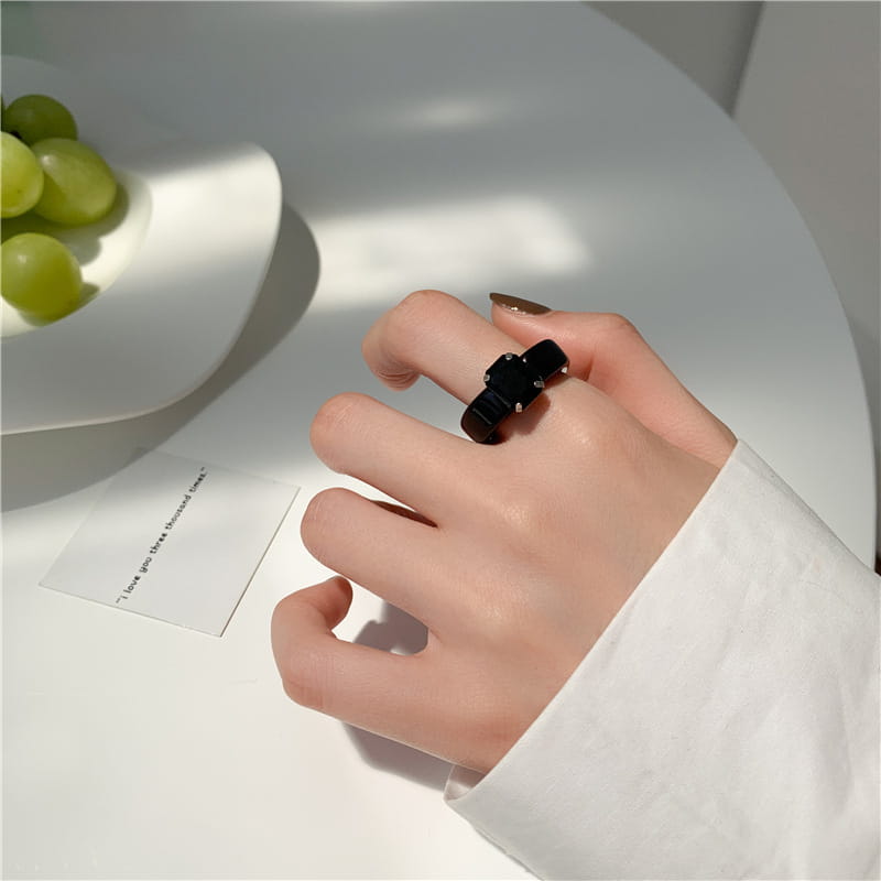 Black ceramic colorful resin crystal geometric ring for women featuring a sleek modern cross design with small silver accents.