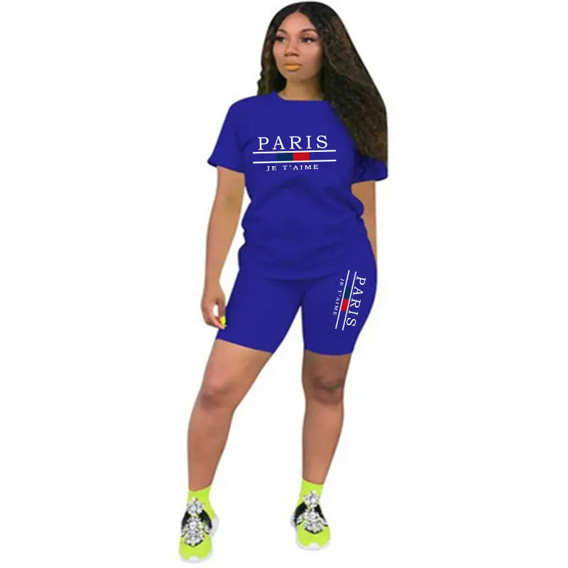 Ensemble deux pièces pour femmes en bleu royal vif : haut à enfiler avec fermeture et short, comprenant le texte « Paris je taime » et des accents de drapeau français sur le t-shirt et le short.
