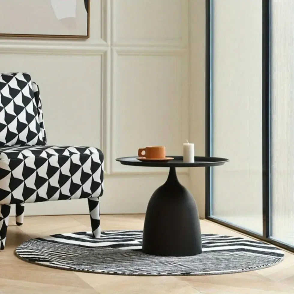 Black ceramic coffee table with a sleek modern design and rounded top ideal for a living room side table.