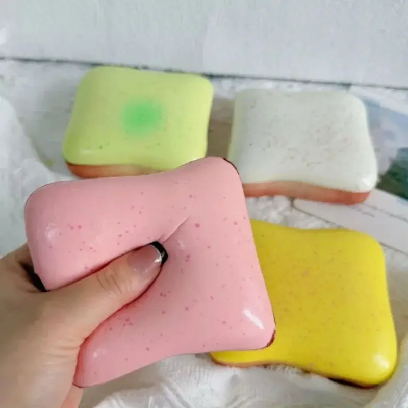 Jouet anti-stress en forme de toast moelleux rose, couleur macaron, avec une texture tachetée et une finition brillante.