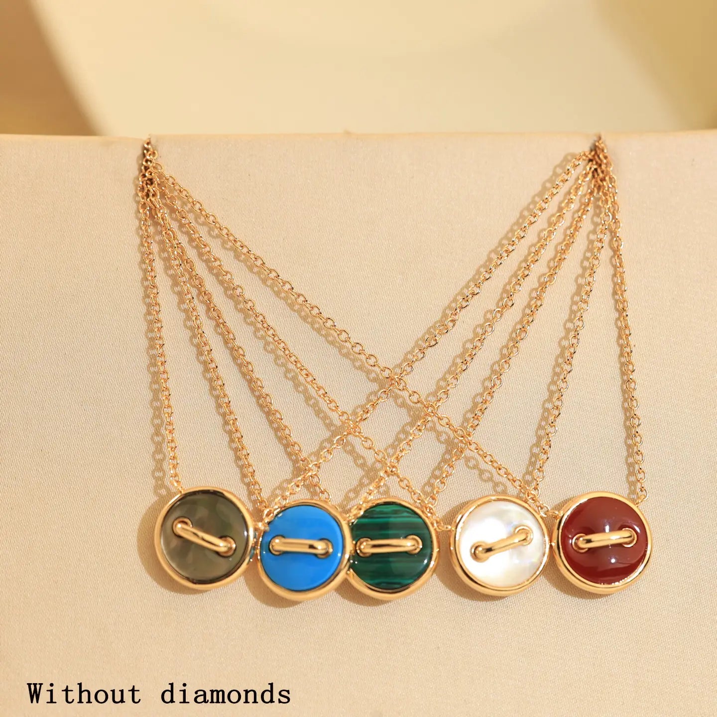 Colliers boutons doubles en or rose, en argent sterling, présentant cinq pendentifs ton sur ton avec des pierres cabochon rondes en vert, bleu, émeraude, nacre et rouge.