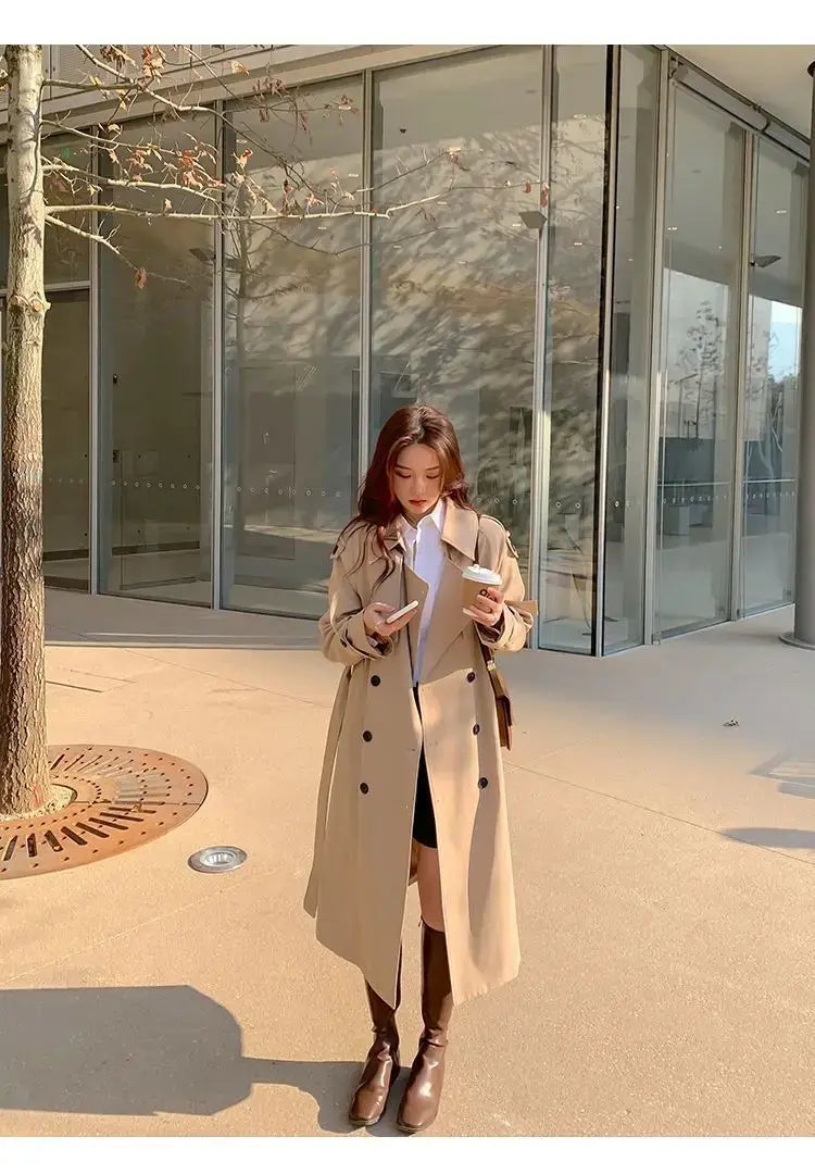 Beige women double-breasted trench coat with black buttons designed as a casual windbreaker.