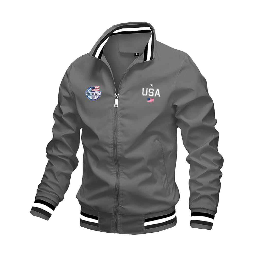 Chaqueta tipo bomber USA para hombre color gris, con ribetes a rayas negro y blanco en el cuello, los puños y la pretina, con gráfico de letras tipo varsity y un pequeño parche de bandera estadounidense para uso casual.