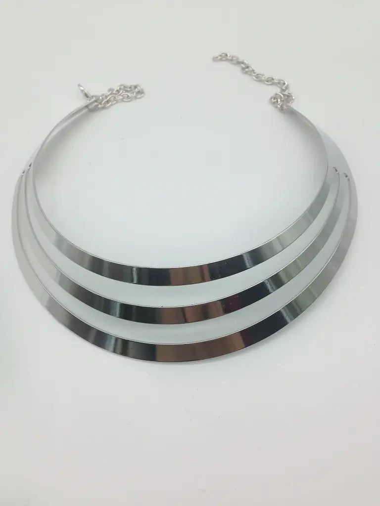 Collar tipo gargantilla metálico plateado multicapa con tres bandas anchas concéntricas y broche de cadena en estilo de cadena punk.