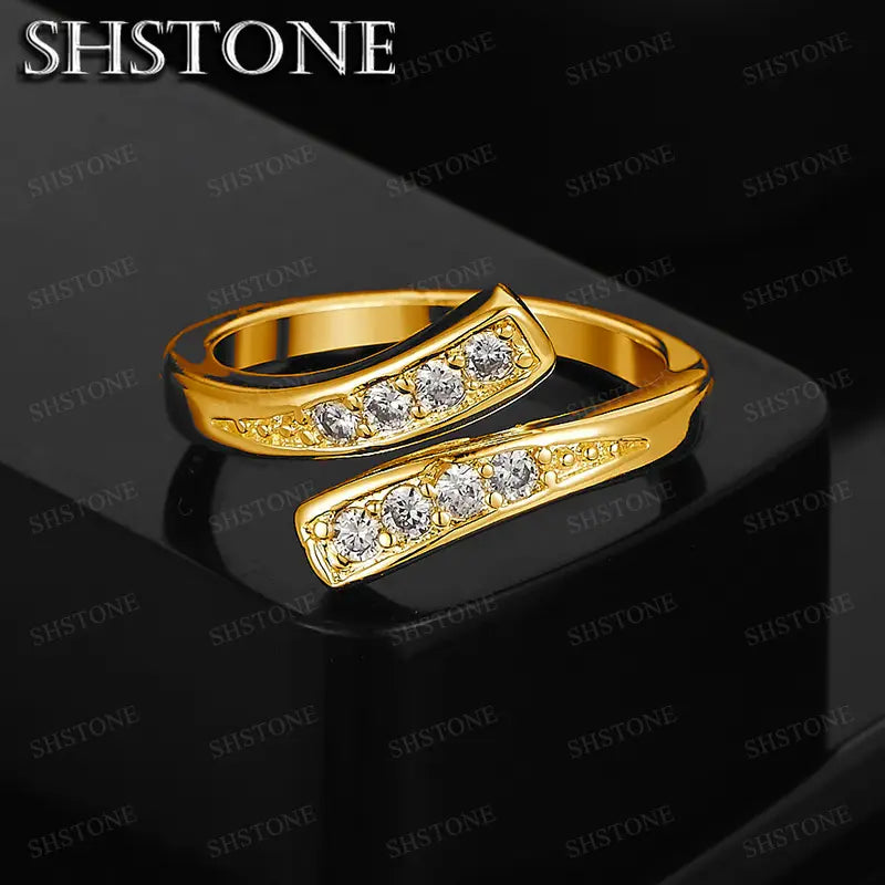 Verstellbarer Zirkonring aus 18k Gold für Damen mit einem goldfarbenen Hochzeitsband, das fünf klare, runde Schliffformen aufweist, eingebettet in ein elegantes, modernes Design.