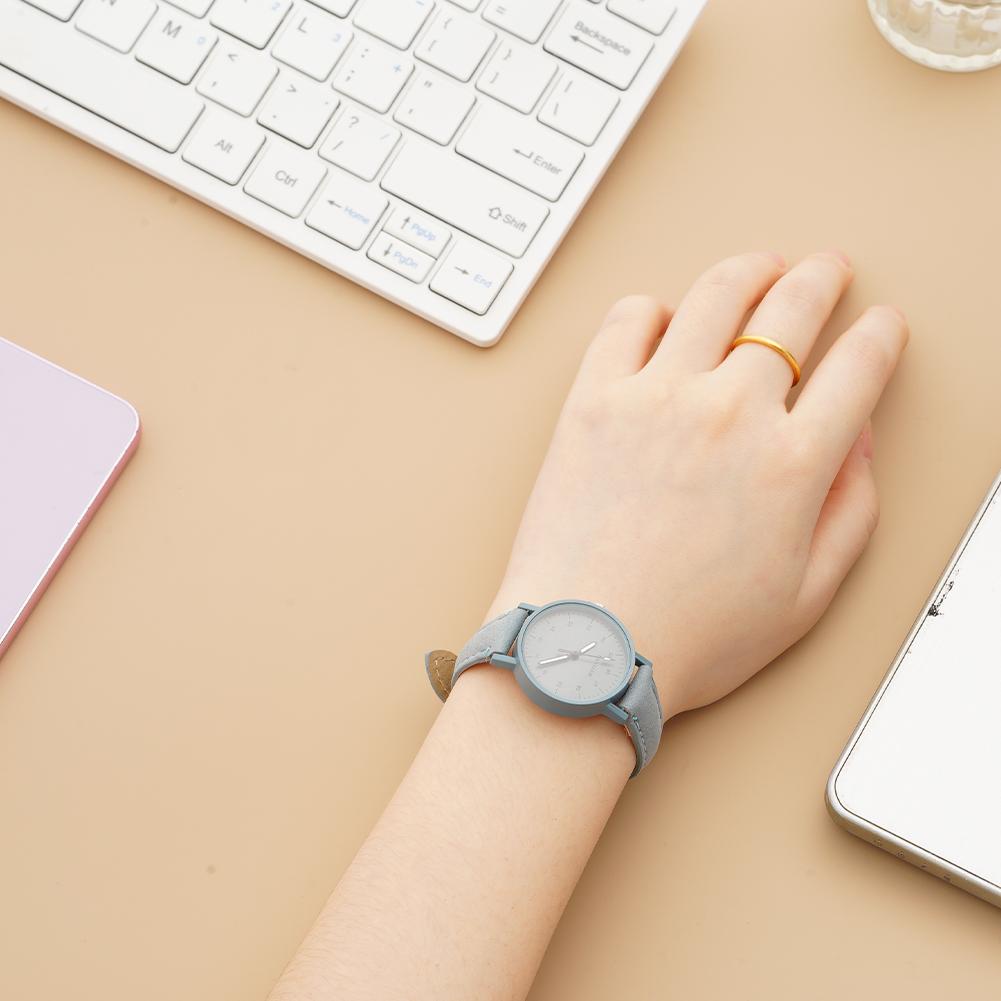 A minimalist gray women quartz watch with a round face and pu leather waterproof strap featuring subtle gold-tone accents on the clasp.