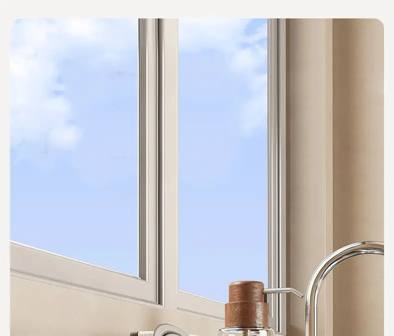 Un organizador para fregadero de cocina de acero inoxidable que incluye un dispensador de jabón transparente de vidrio con un elegante diseño, con una parte superior de bomba de madera color marrón cálido, junto a un grifo cromado moderno.