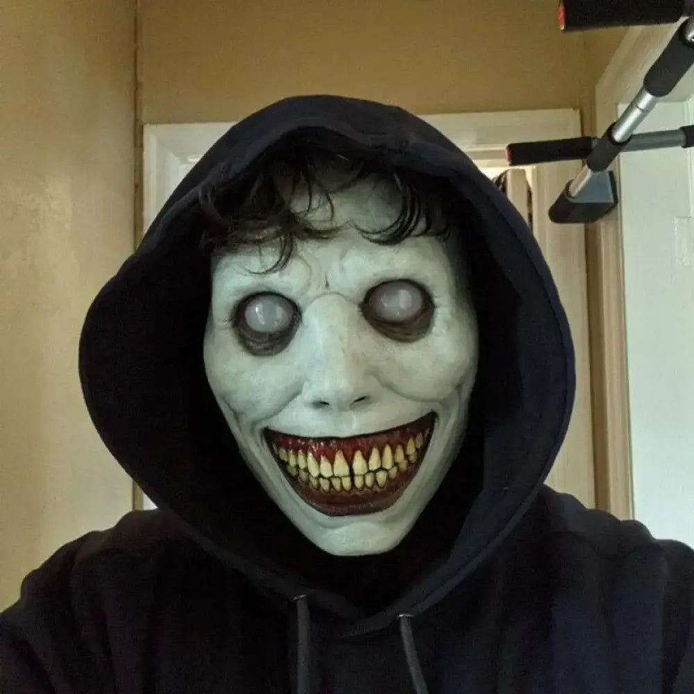Black hooded sweatshirt with a white resin horror mask featuring large hollow eyes and sharp yellow teeth for a creepy Halloween full face costume accessory.