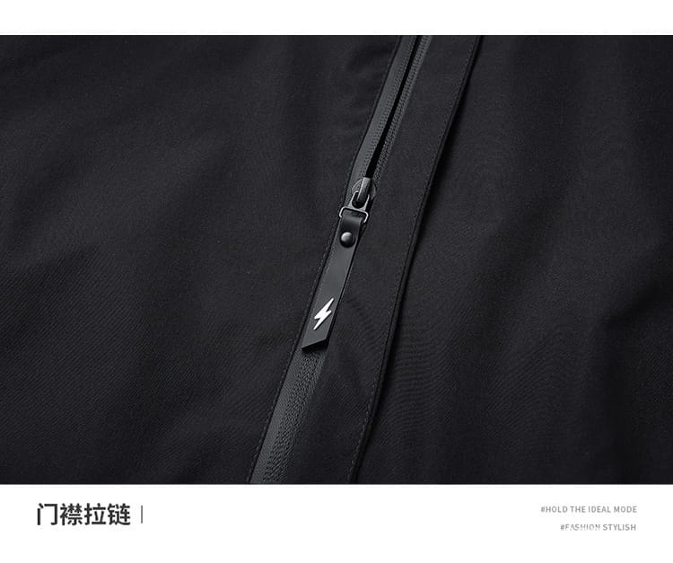 Tirador de cremallera negro con un emblema de rayo plateado en una chaqueta impermeable con capucha para hombre diseñada para actividades al aire libre.
