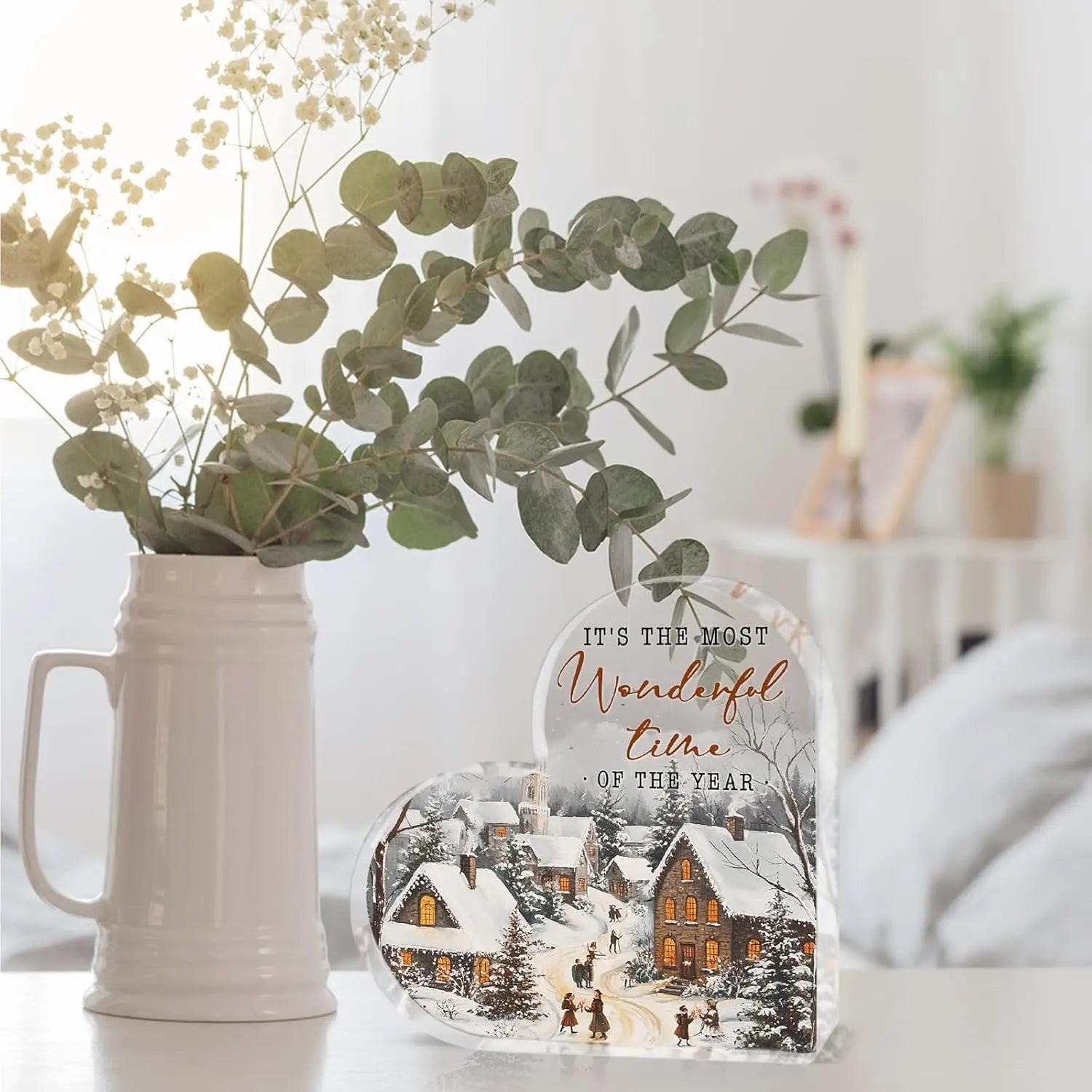 Décoration de table de Noël en acrylique en forme de cœur, comportant un motif en forme de cœur avec une scène de village enneigé éclairée et le texte « it is the most wonderful time of the year », éclairé de l’intérieur.