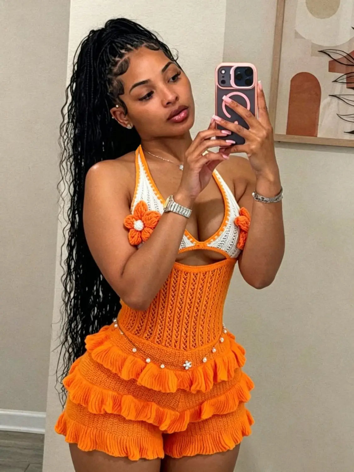 Orange and white crocheted knitted ruffle halter romper summer playsuit with floral embellishments and ruffled skirt detail.