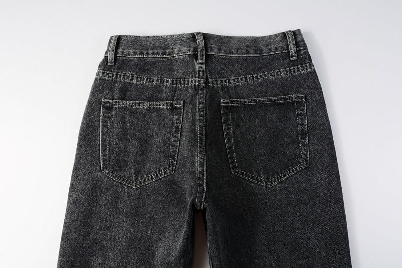 men flare jeans distressed dark gray denim trousers shown from the back with a faded worn-in texture and classic back pockets