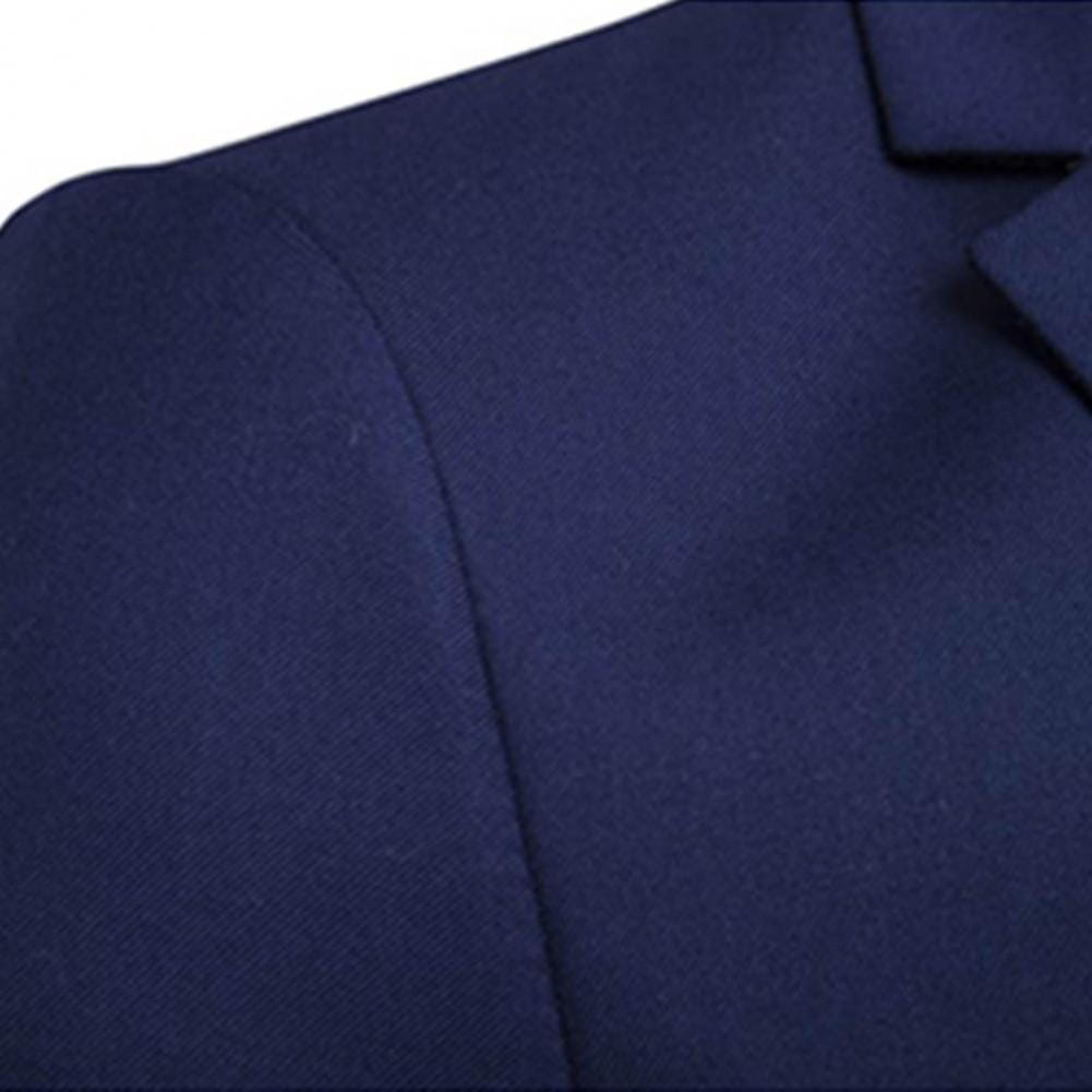 Abrigo de lana color azul marino con hombro estructurado y un acabado limpio de costuras, como parte de un conjunto de traje formal de hombre de color sólido, chaqueta de manga larga y pantalones, que muestra el largo de los pantalones y el diseño de la manga larga.