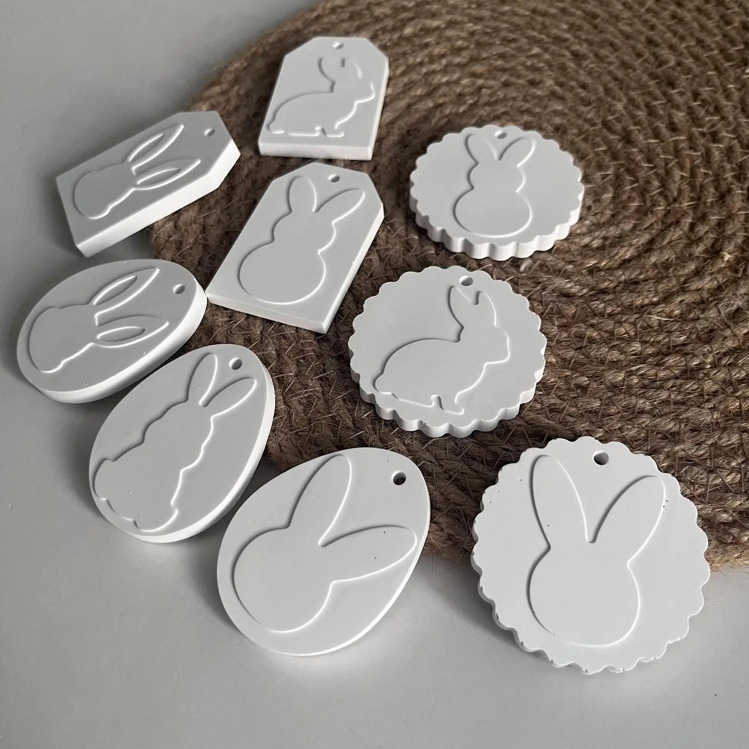 white bunny-shaped tags in various shapes and sizes made of smooth matte-finished plastic shown in an Easter bunny silicone resin pendant mold product.