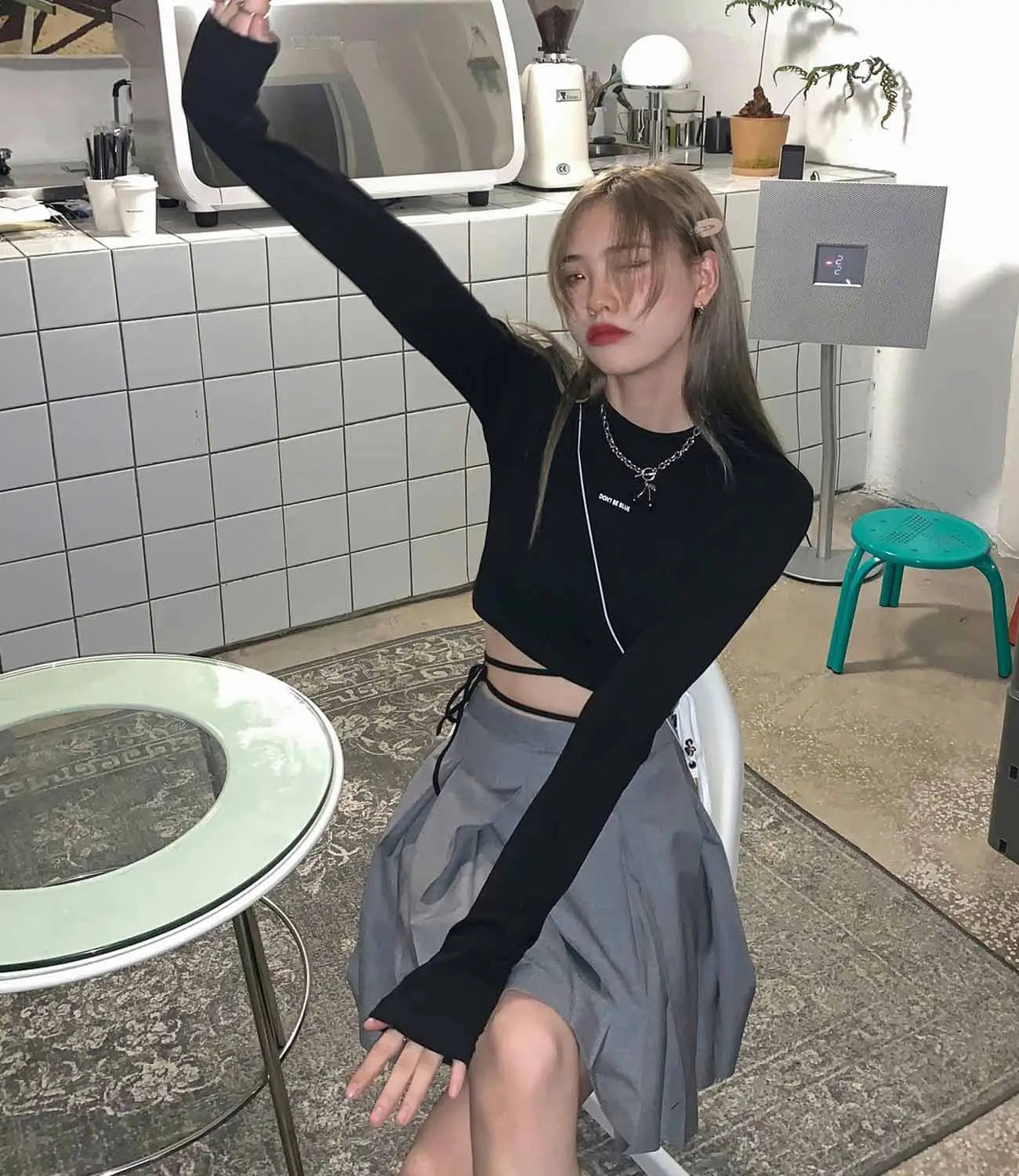 Schwarzes Damen-Langarm-Crisscross-Crop-Top mit Cutout-Seiten und gerippter Struktur aus bequemem Stretchmaterial.