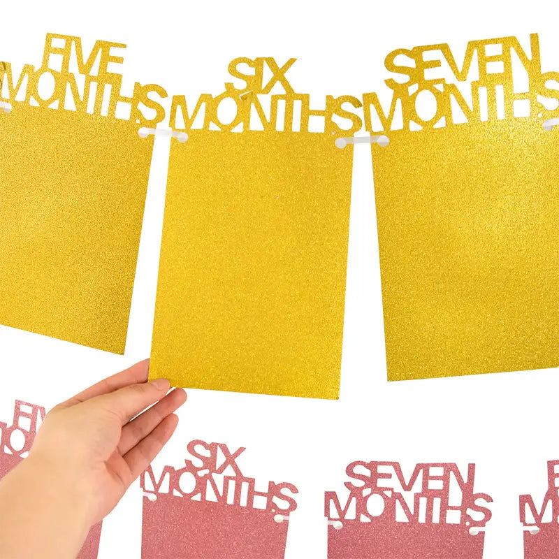 gold glittery 1st birthday photo banner featuring cut-out text reading five months six months and seven months on rectangular panels for monthly picture garland display