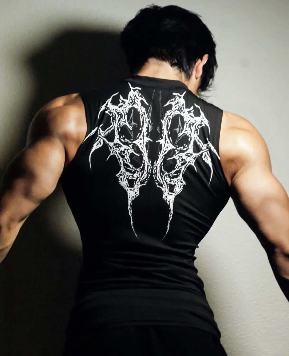 Camiseta sin mangas negra de secado rápido, tipo top deportivo, con intrincado diseño de alas blancas estilo gótico en la espalda para uso en fitness.