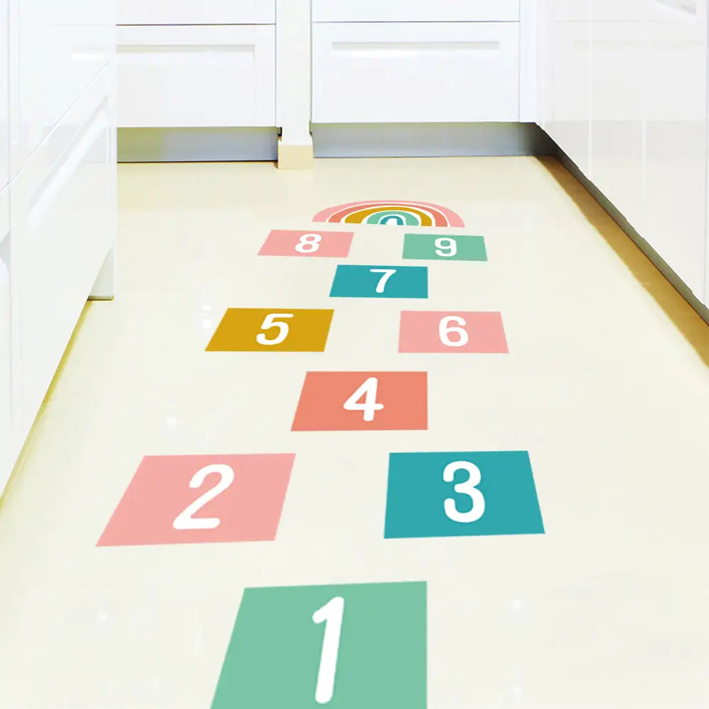 3D-Nummer-Hüpfspringen-Bodenaufkleber mit farbenfrohen rechteckigen Regenbogen- und weißen Ziffern, die in einem Hüpfspringen-Muster für Wandkunst und Deko im Spielbereich angeordnet sind.