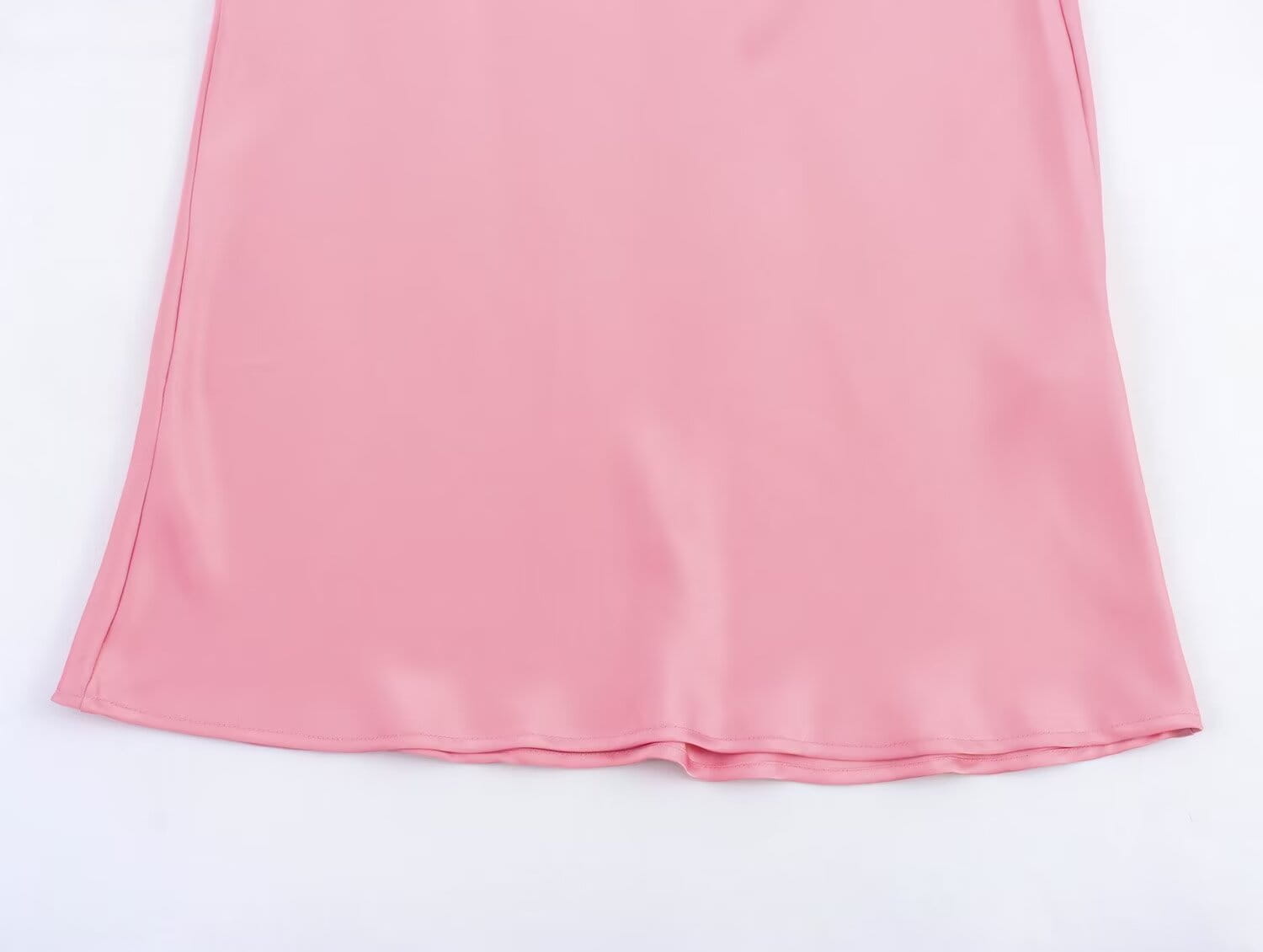 Une jupe midi en satin rose tendre, à taille haute, ourlet fluide et lisse, conçue comme une longue jupe élégante.