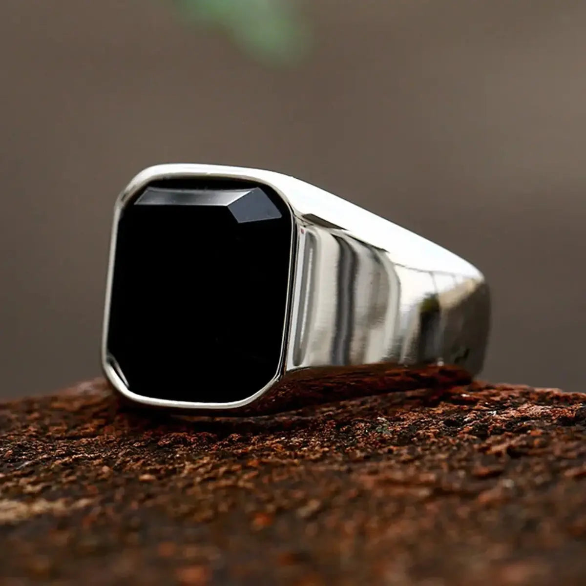 Ein eleganter Signetring aus Silber für Damen und Herren, mit einem markanten schwarzen Onyx-Stein, der in einer rechteckigen facettierten Fassung eingesetzt ist.