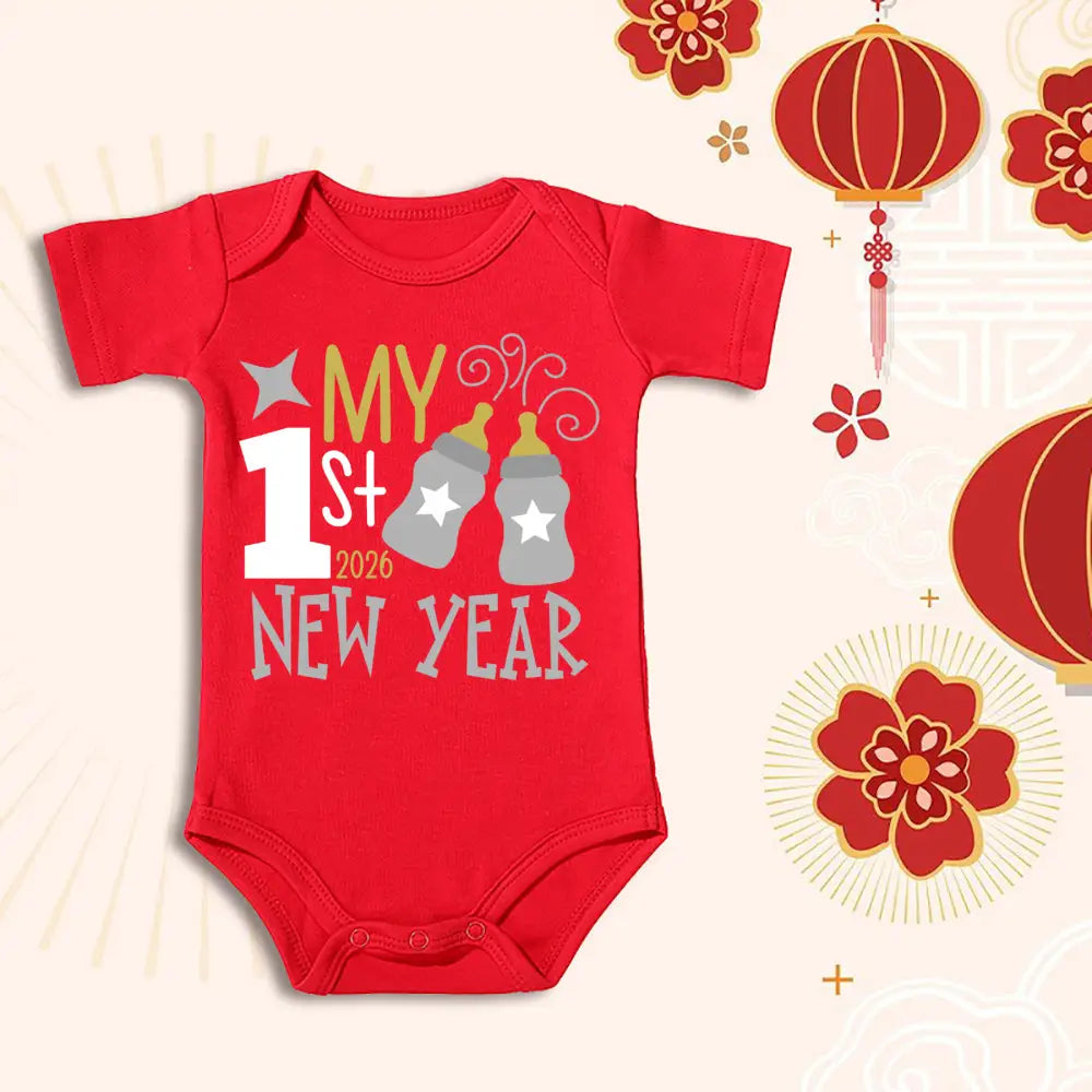 Combinaison-bermuda en coton rouge pour bébé, arborant « Mon 1er nouvel an 2026 » imprimé en blanc et en doré, avec deux biberons de lait gris ornés d’étoiles.