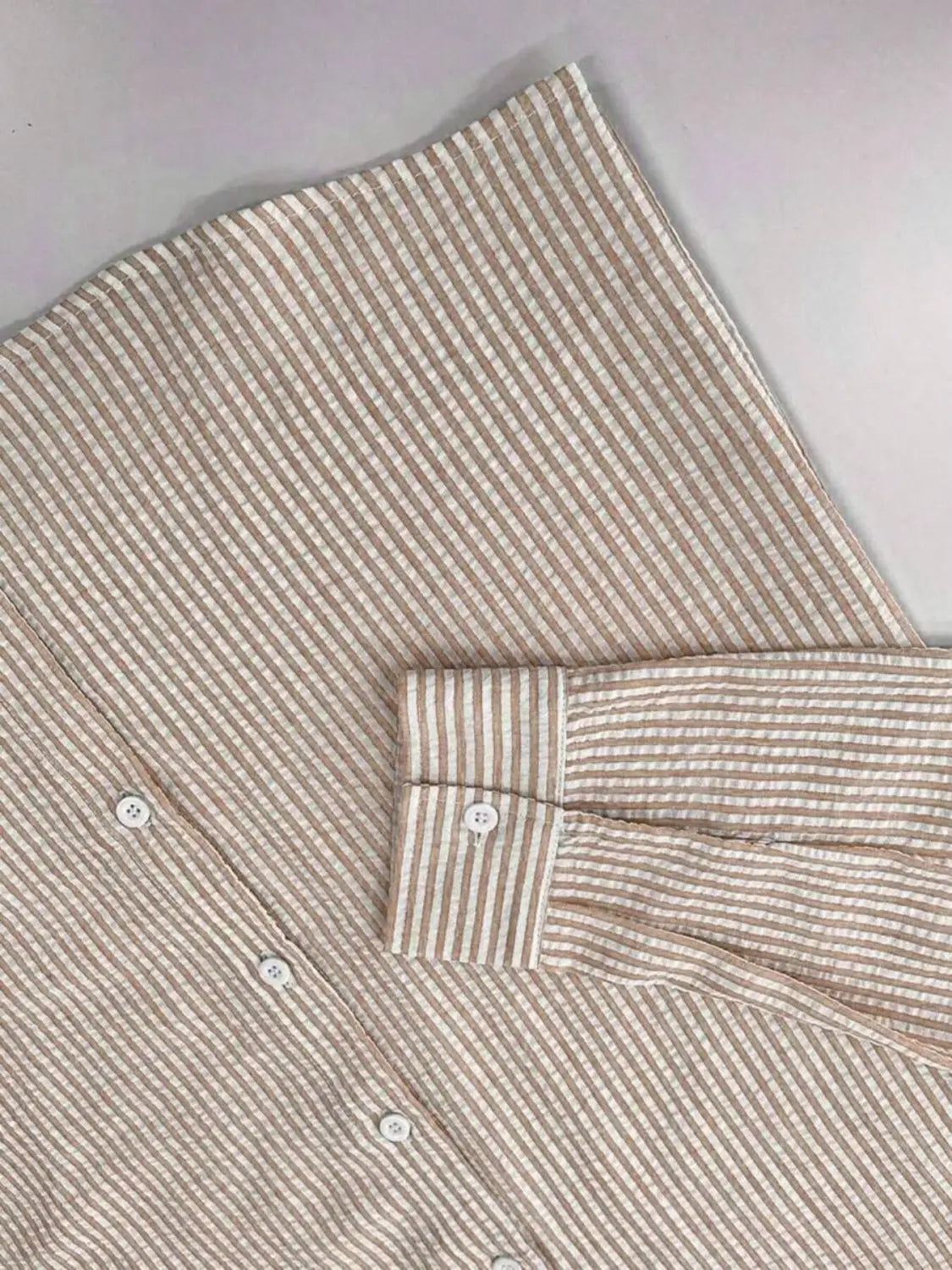 Chemise décontractée boutonnée manches longues à rayures bleues pour homme, en beige et rayures verticales blanches, avec col et poignets classiques.