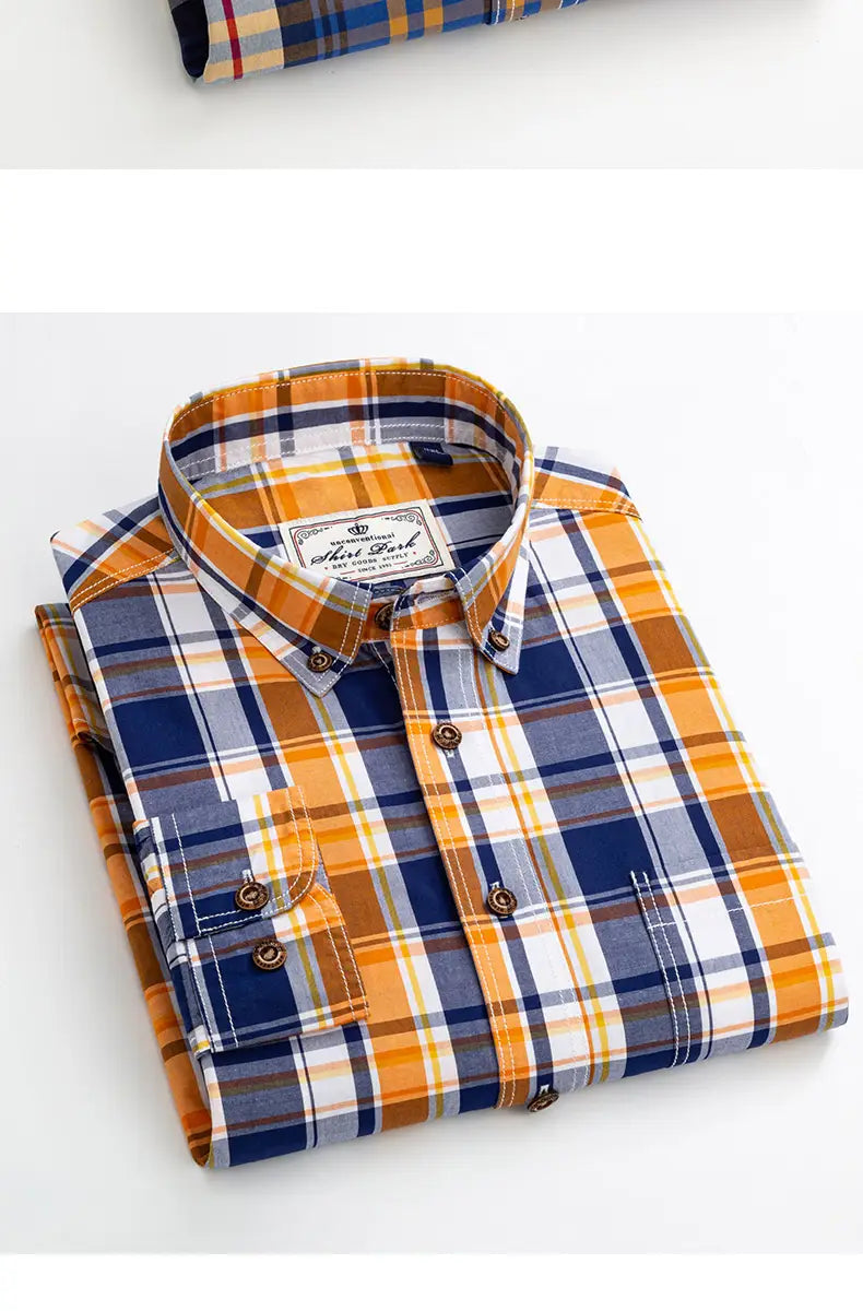a neatly folded men’s cotton slim fit long sleeve shirt featuring a bold plaid pattern in navy blue orange and white with matching brown buttons