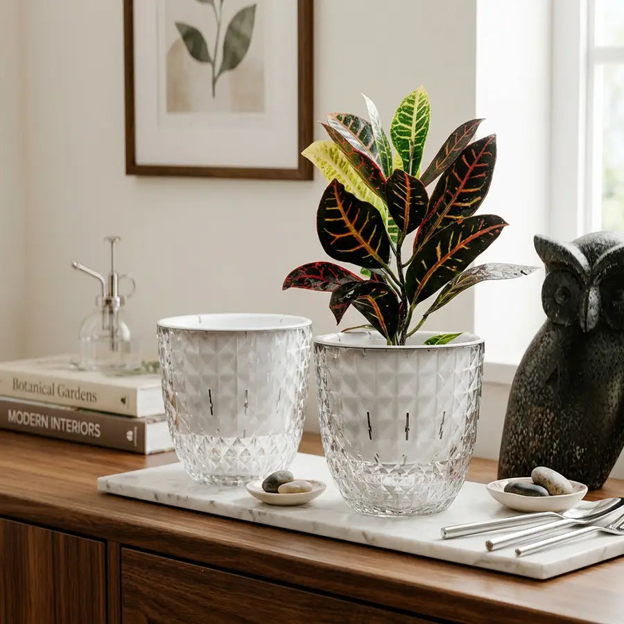 Dos jardineras de vidrio facetadas transparentes con un patrón geométrico tipo diamante y líneas verticales sutiles que presentan un diseño doble con riego automático para un cuidado eficiente de las plantas.
