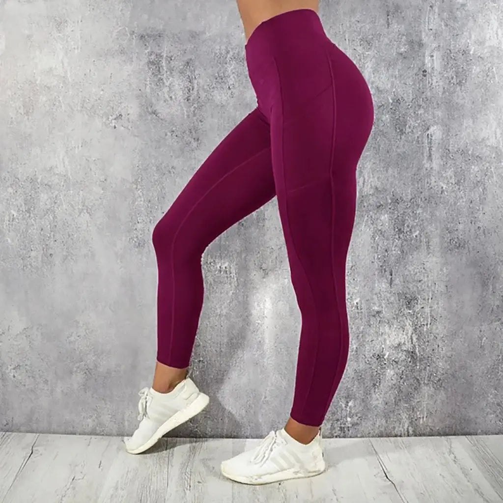 fitted magenta high waist booty lifting pocket leggings made of smooth stretchy fabric with subtle side seam detailing