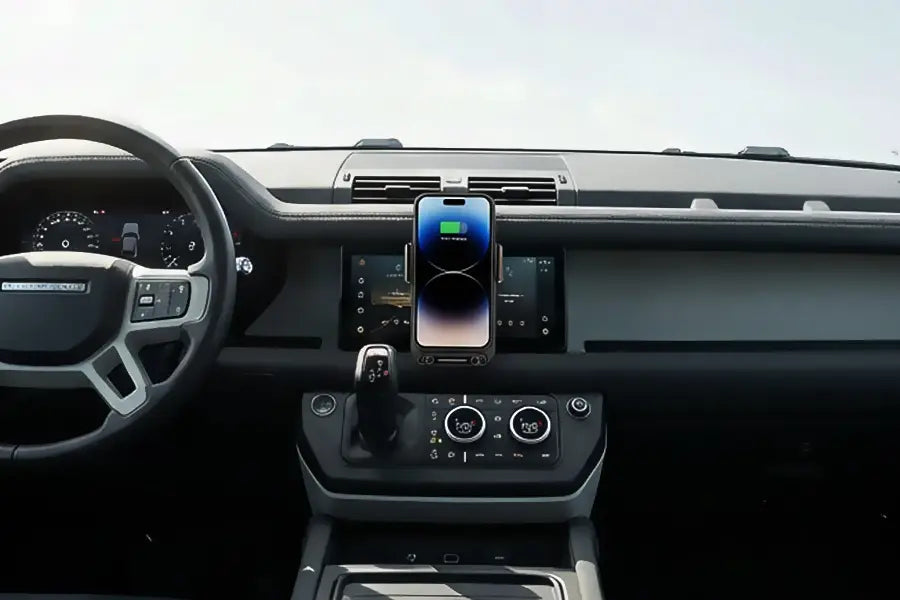 A sleek black glossy smartphone displaying its charging status on the screen mounted on a wireless car phone charger 15w mount.